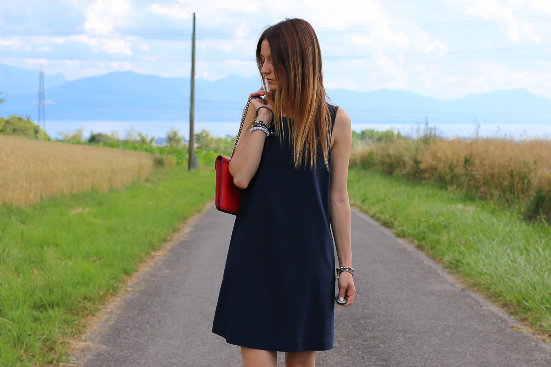 robe de cocktail courte bleu marine col américain avec sac rouge à main 